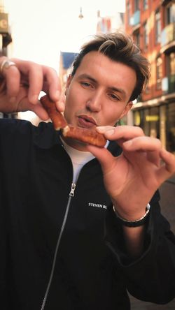 Person holding a homemade burger from Maijard Smashburgers outside in an urban Amsterdam setting
