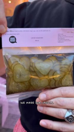 Heart-shaped homemade pickles in a sealed transparent bag with branding from Maijard Smashburgers