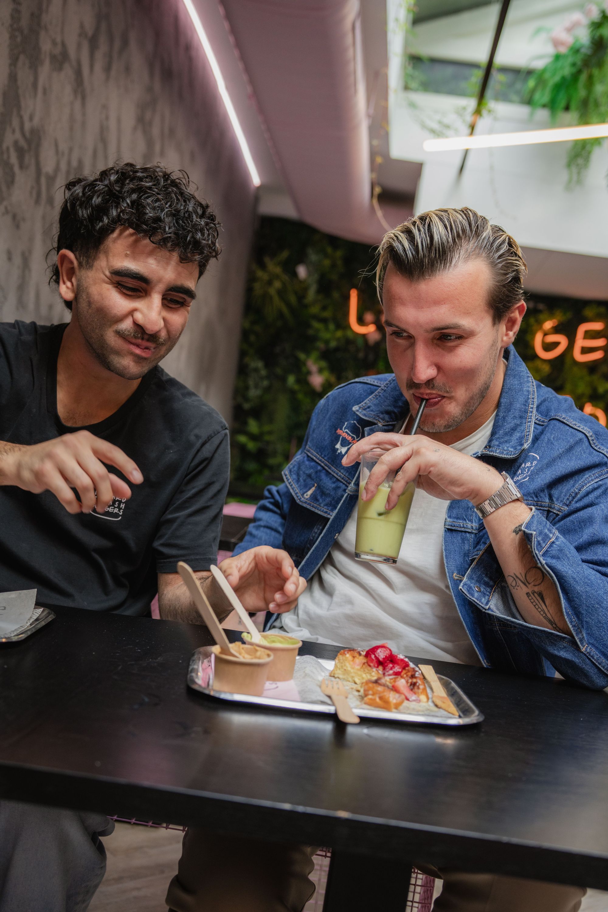 Two customers sitting at Maijard Smashburgers table with burgers and drinks inside the Amsterdam burger bar.