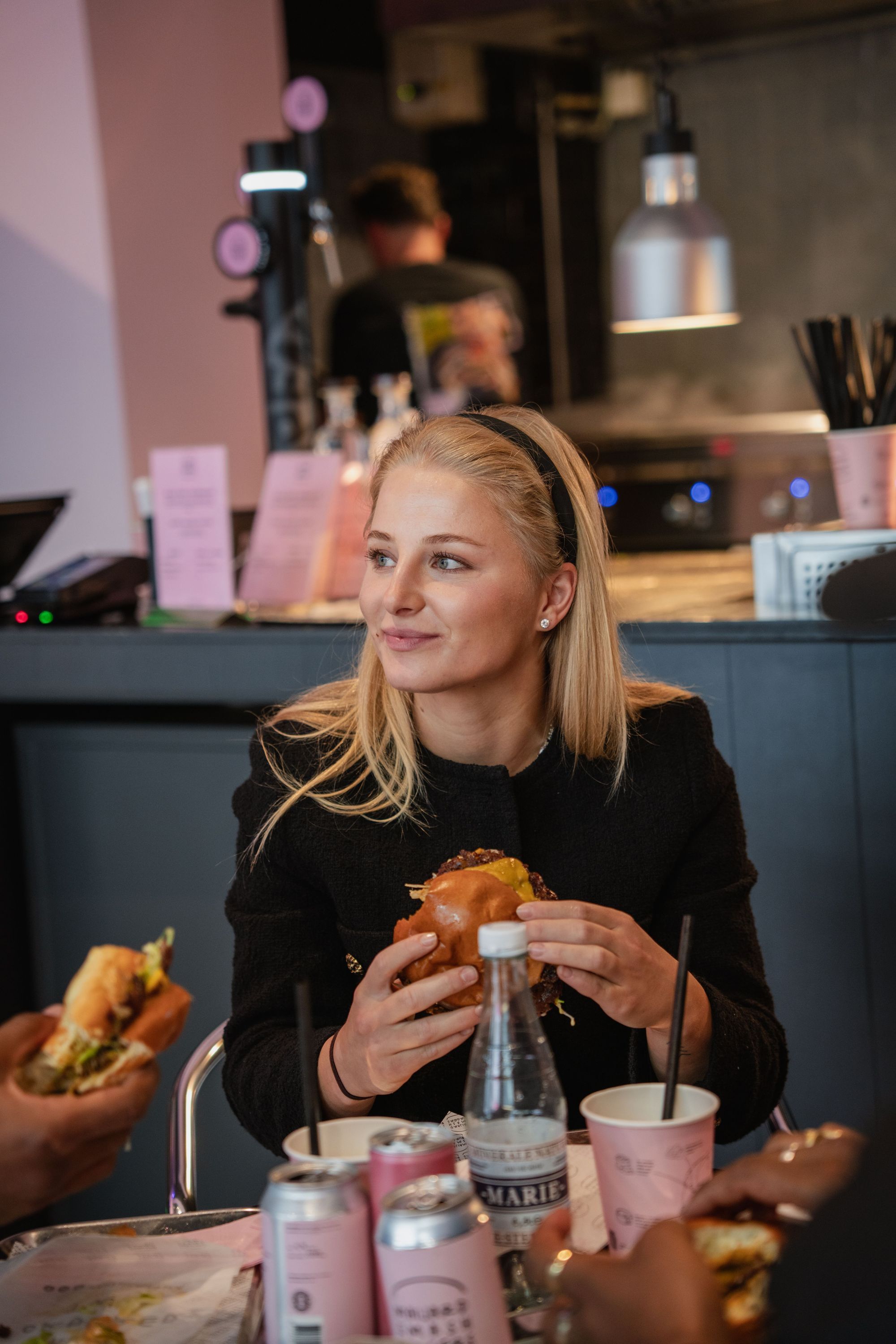 Customer enjoying a homemade smash burger at Maijard Smashburgers in an Amsterdam burger restaurant setting.