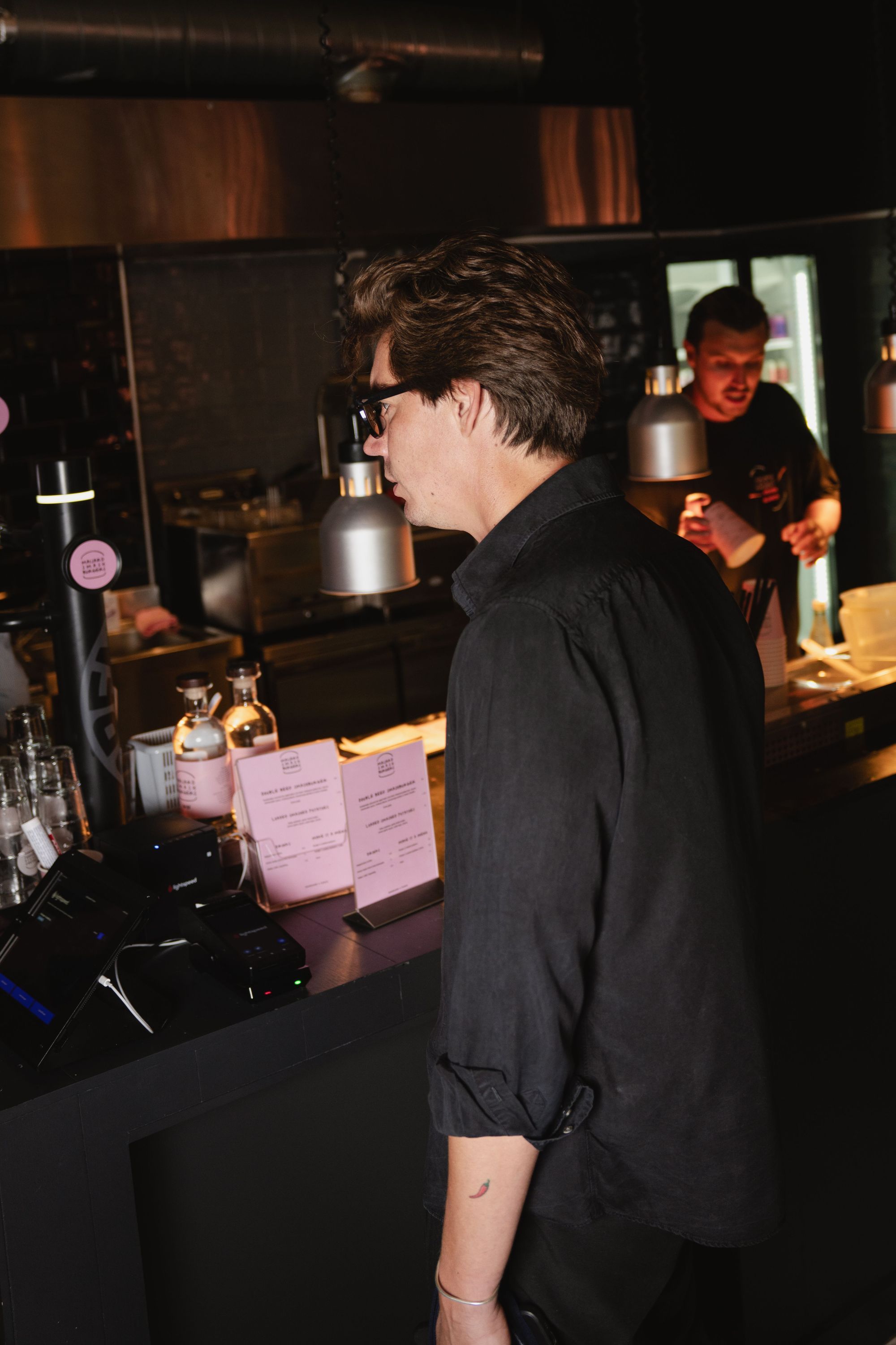 Customer ordering at the counter in Maijard Smashburgers, a burger restaurant in Amsterdam with a modern interior.