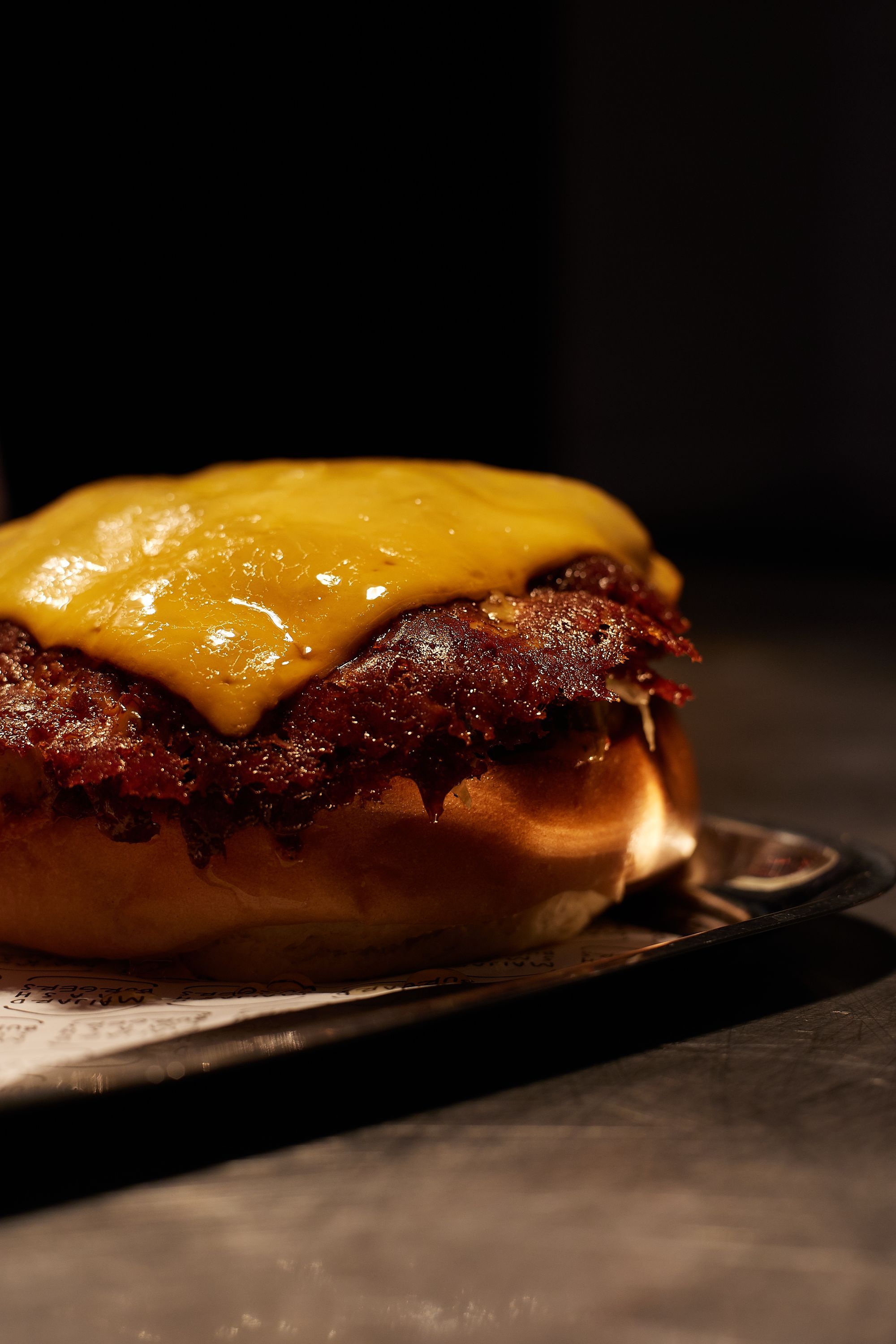 Close-up of a homemade smash burger with melted cheddar cheese on a bun at Maijard Smashburgers in Amsterdam.